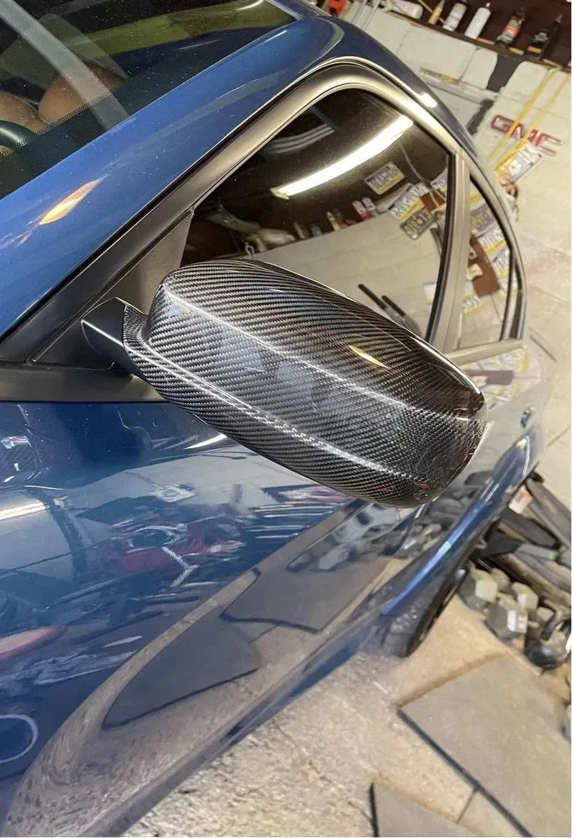 Real carbon fiber side mirror cover on blue sports car, sleek automotive exterior upgrade