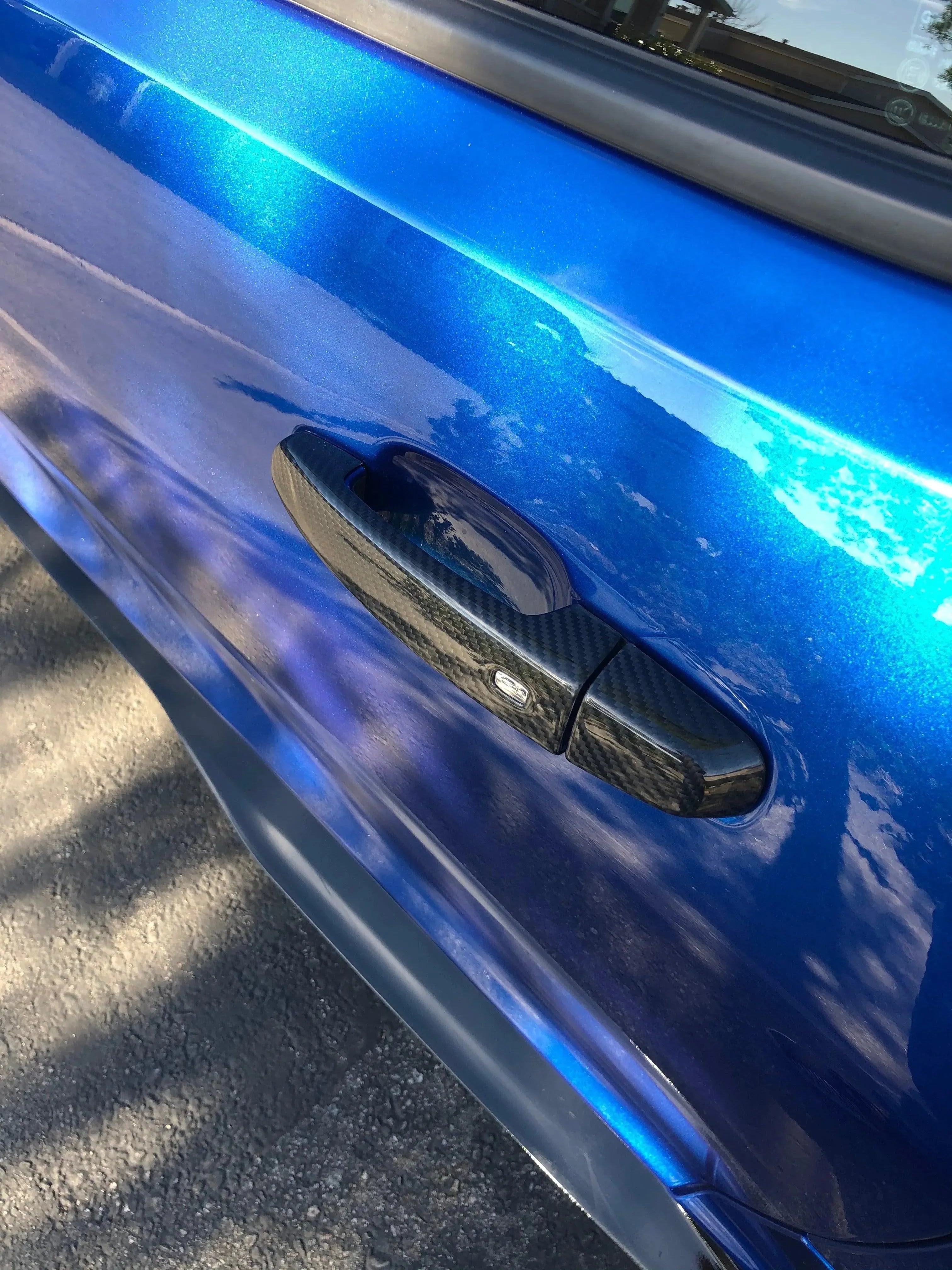 Carbon fiber door handle cover on vibrant blue car, real carbon fiber auto accessory for American vehicles