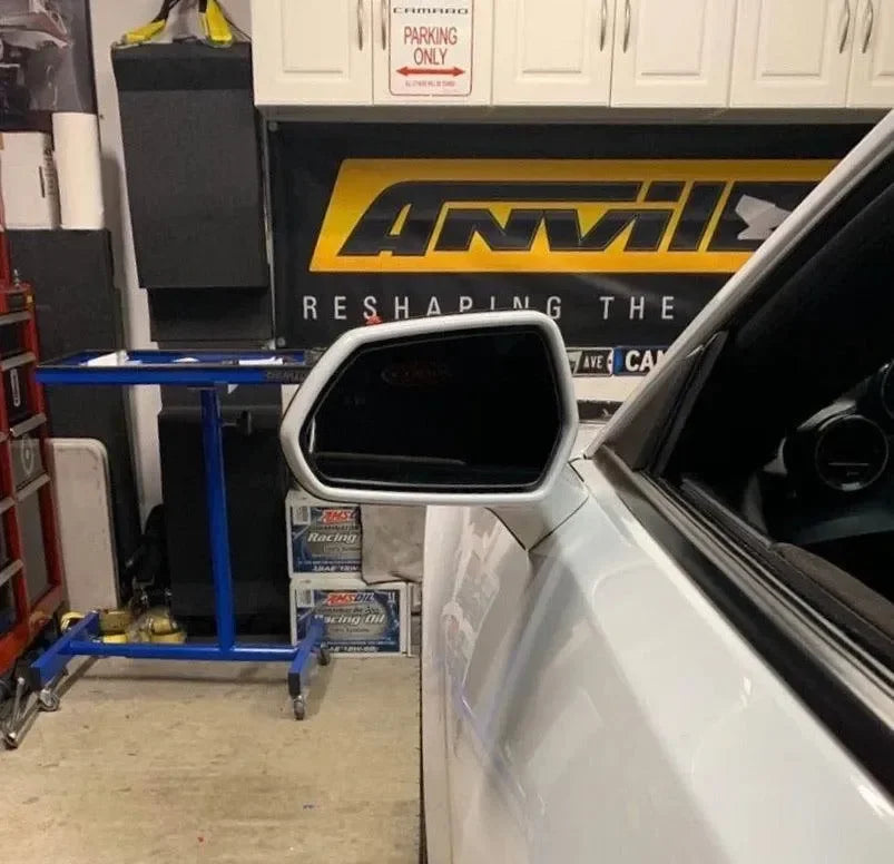 White car with carbon fiber side mirror in garage, featuring Anvil Racing branding and automotive tools