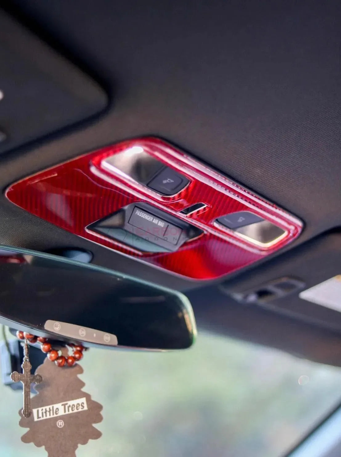 Red carbon fiber interior trim with passenger airbag controls in a car