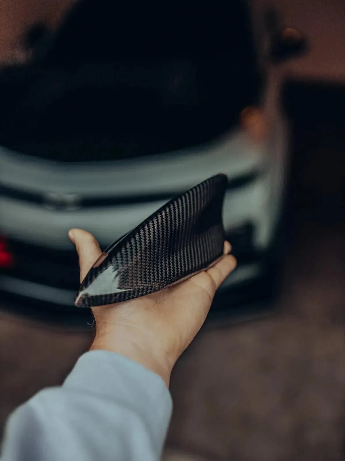 Hand holding real carbon fiber car part for American vehicles like Mustang or Camaro