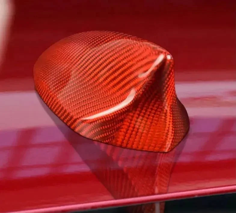 Red carbon fiber car antenna cover on glossy vehicle roof