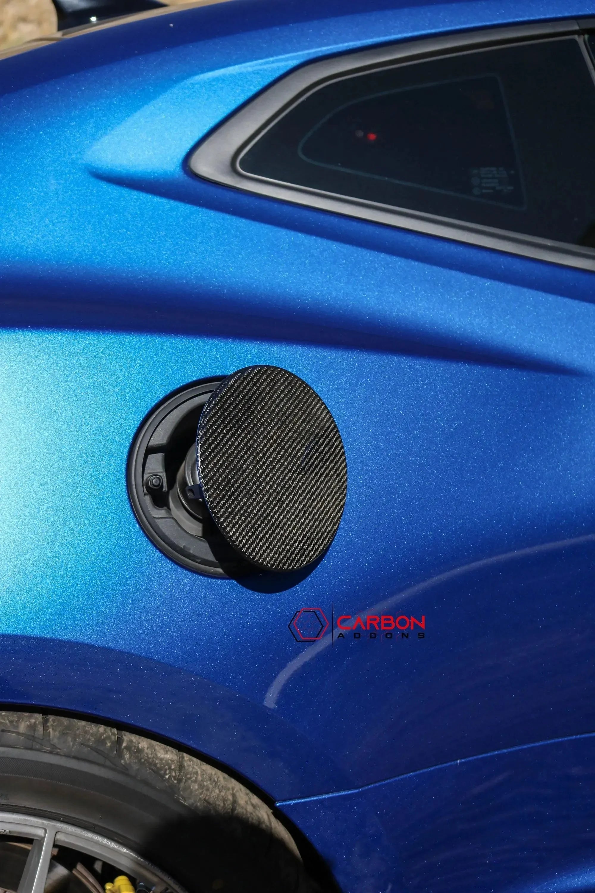 Carbon fiber fuel door cover on a blue American muscle car
