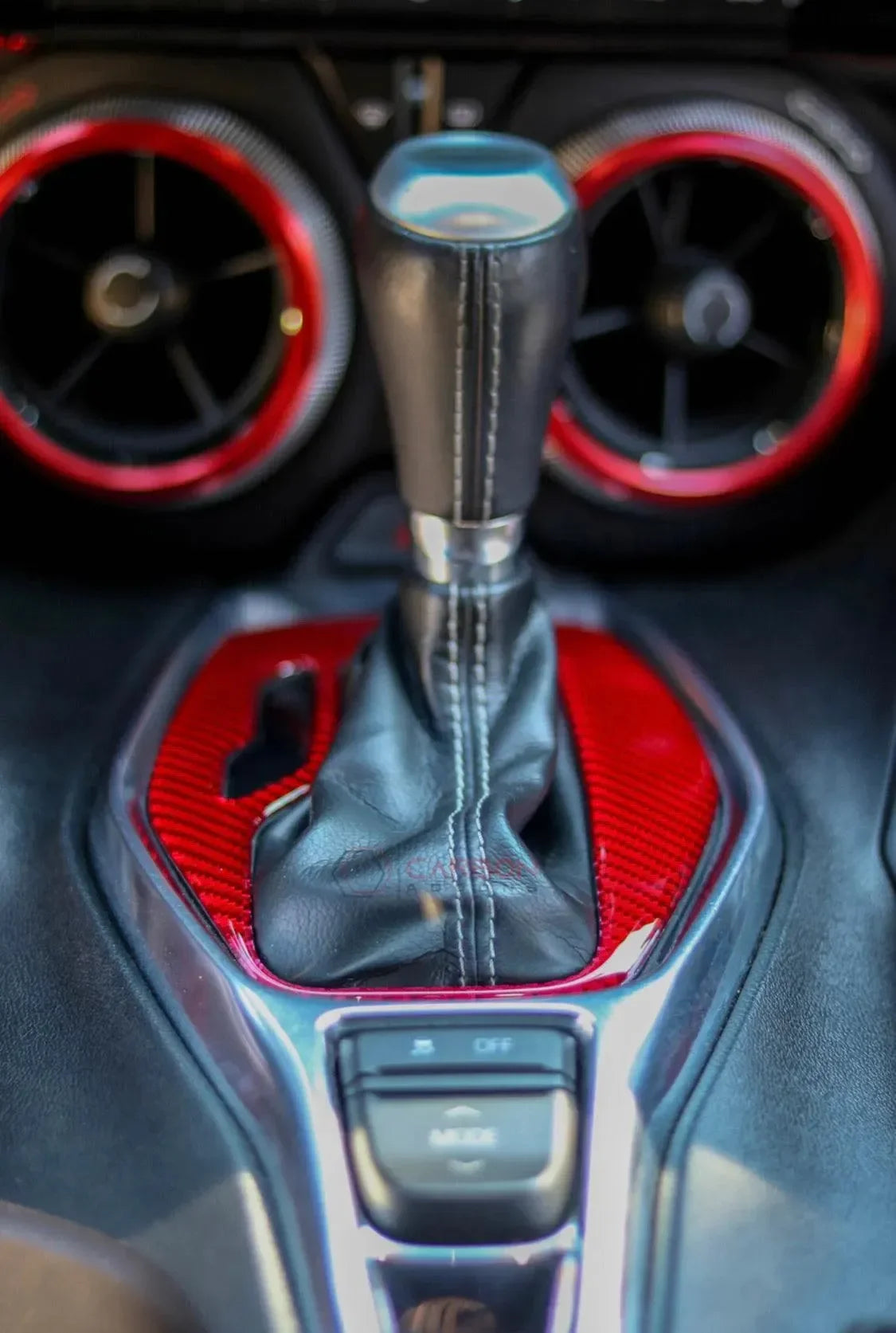 Carbon fiber interior trim with red accents and leather gear shifter for American vehicles