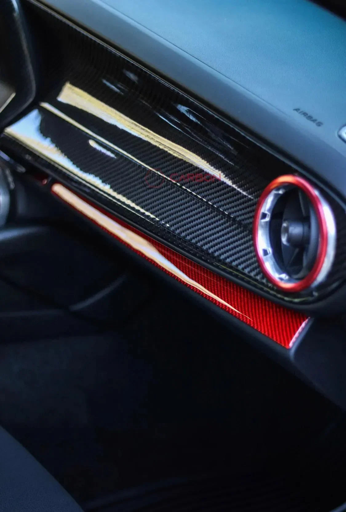 Glossy black and red carbon fiber interior trim with red-accented air vent for American muscle cars