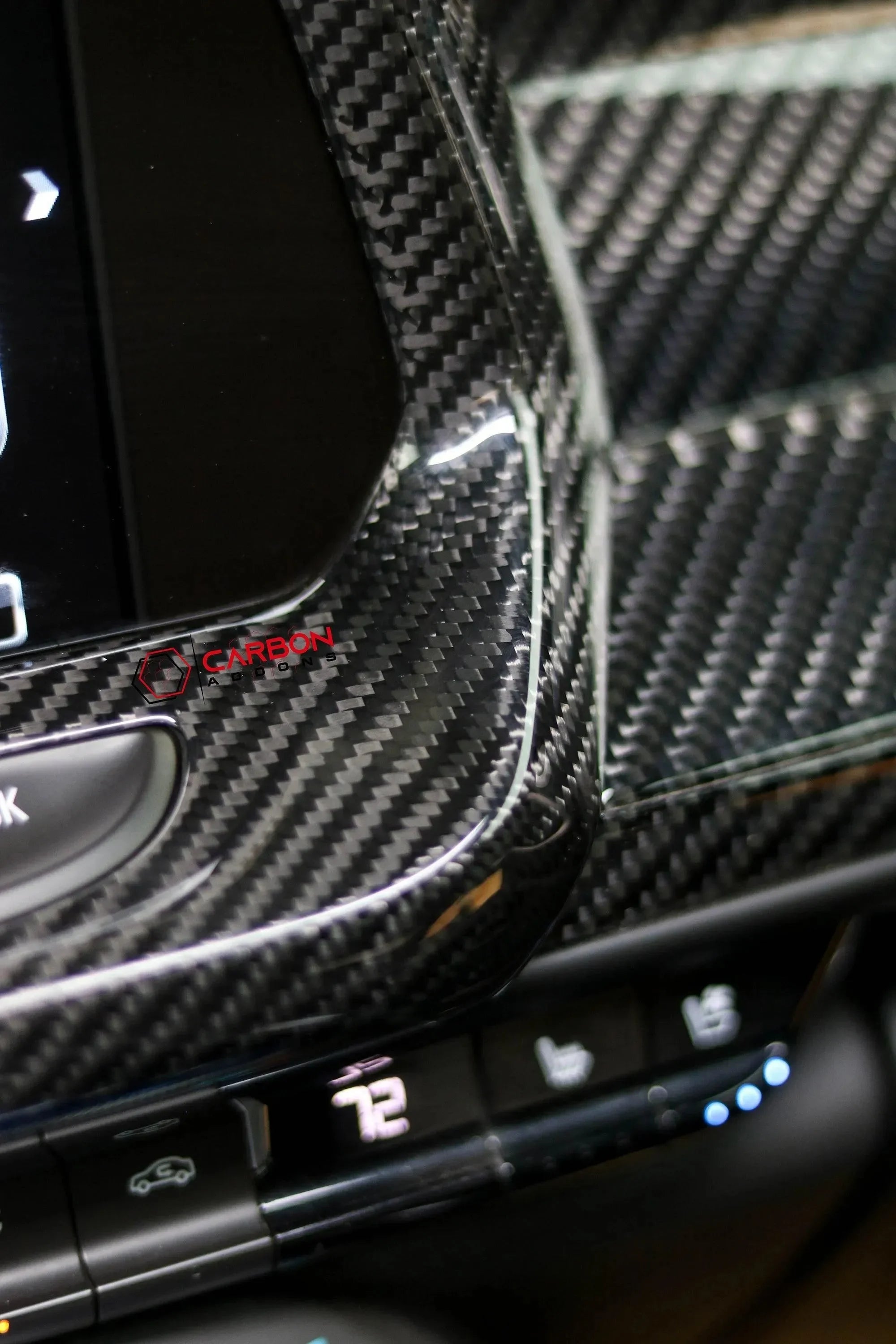 Glossy carbon fiber interior trim with real carbon weave on car dashboard, enhancing luxury and performance look.