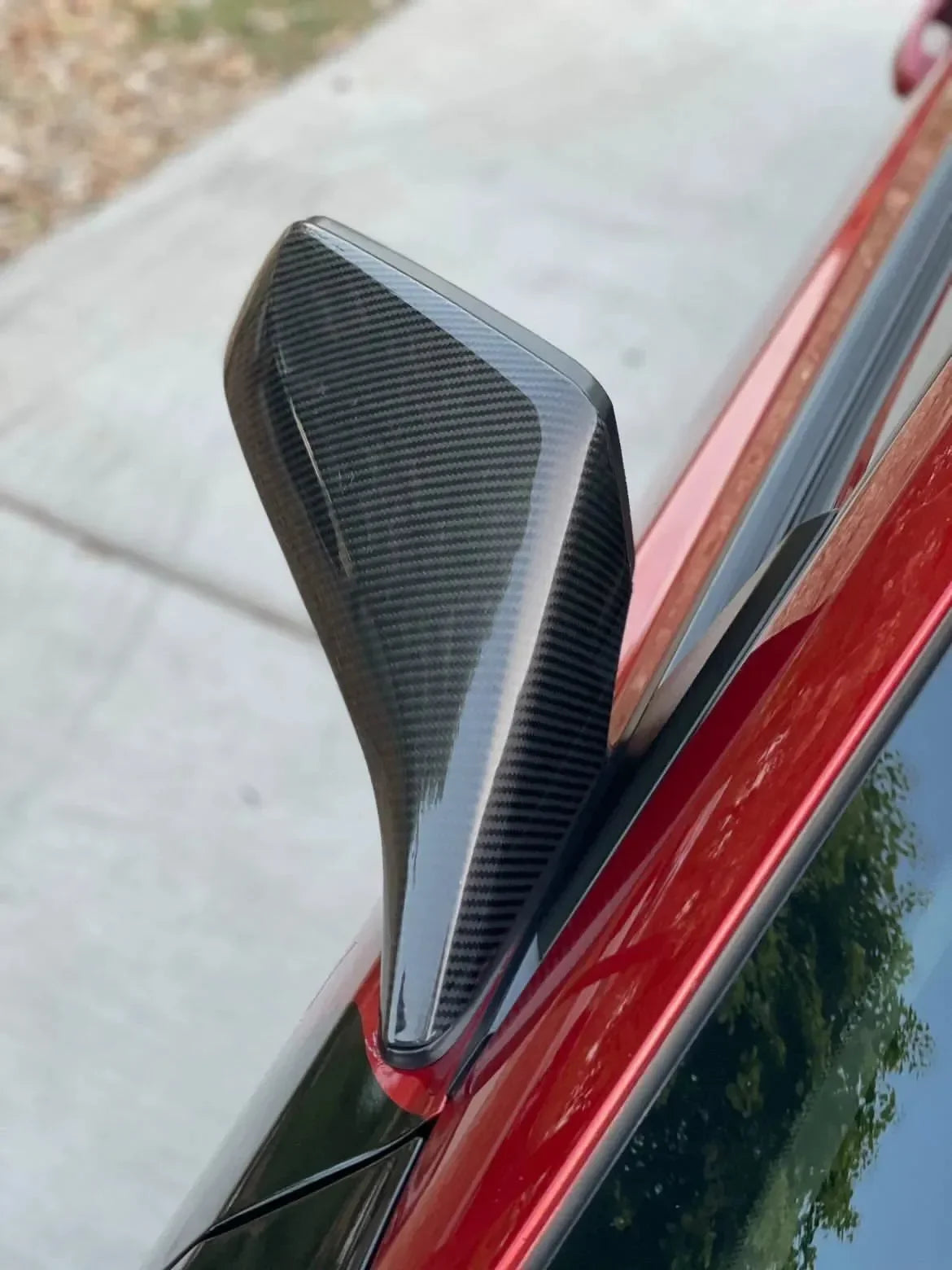 Real carbon fiber shark fin antenna on red car, sleek auto accessory for American vehicles