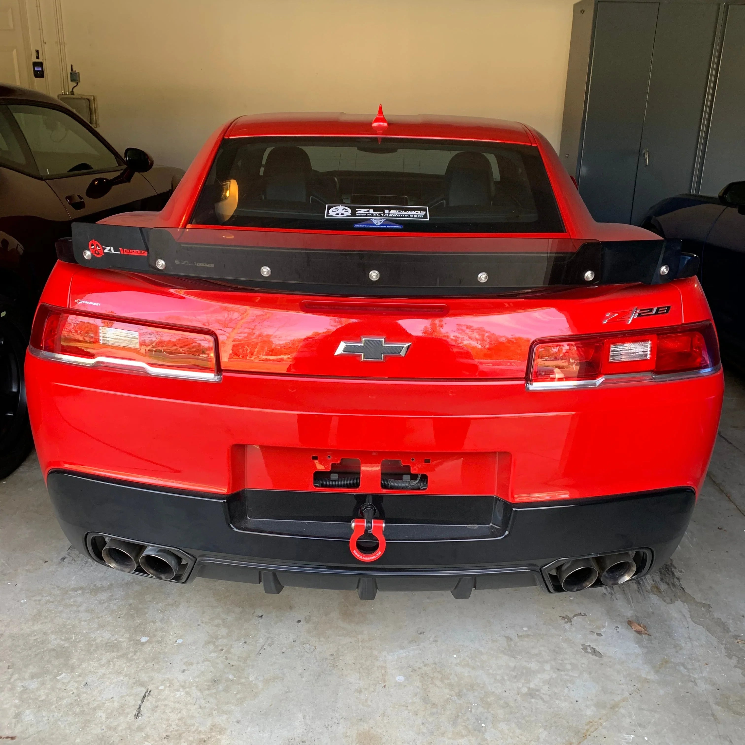 Red Chevrolet car with a black spoiler in a garage