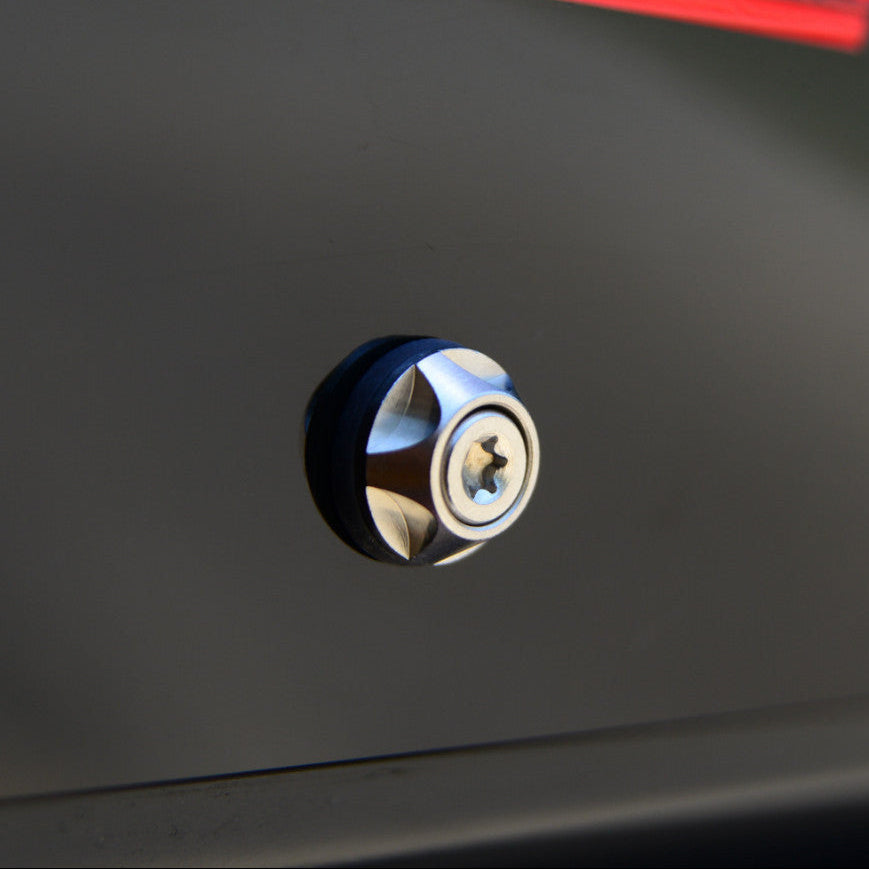 Close-up of a metallic screw on a dark surface