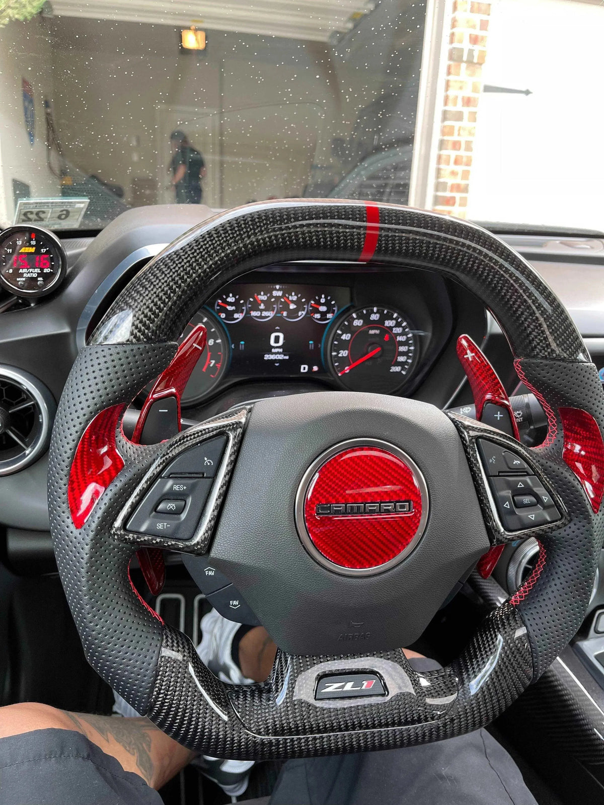 Chevy Camaro ZL1 steering wheel with real carbon fiber wrap and red accents, showcasing custom interior upgrade.