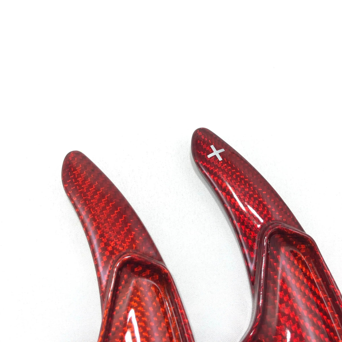 Red carbon fiber car paddle shifters with glossy finish and plus symbol