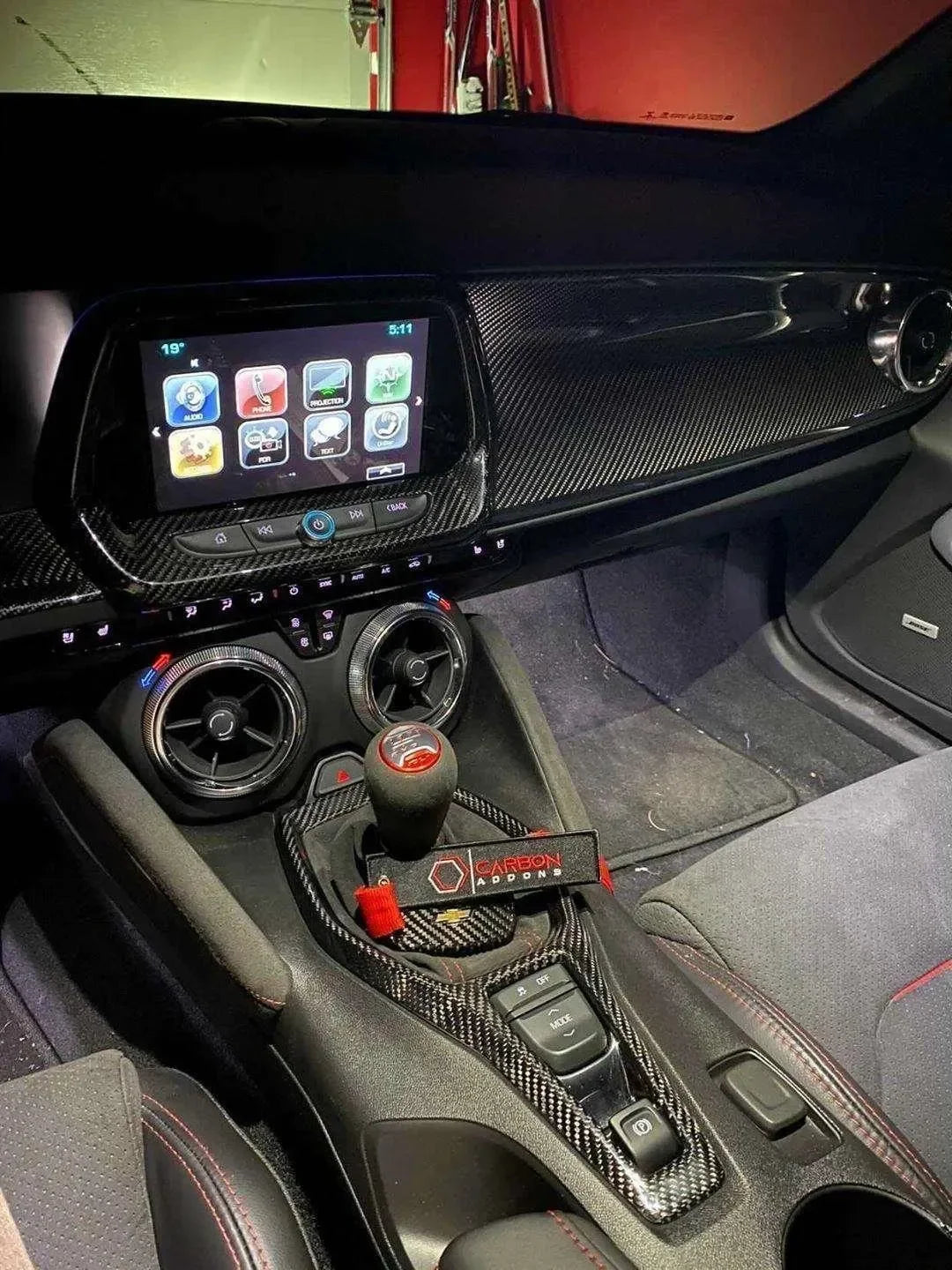 Carbon fiber interior upgrade for Chevy Camaro with sleek dashboard and gear shift accents