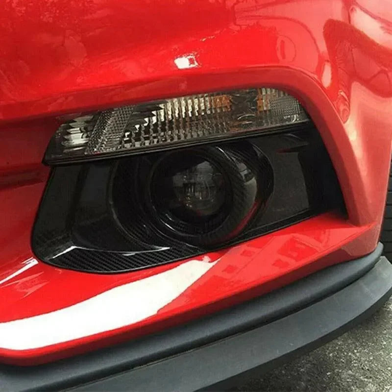 Carbon fiber headlight trim on red American muscle car