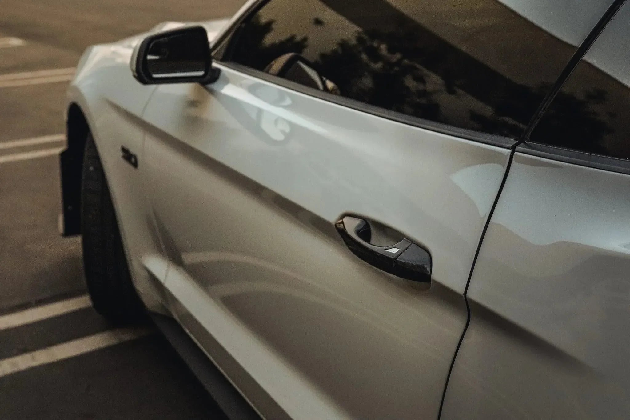White Ford Mustang with real carbon fiber door handle and side mirror accents for custom automotive styling.