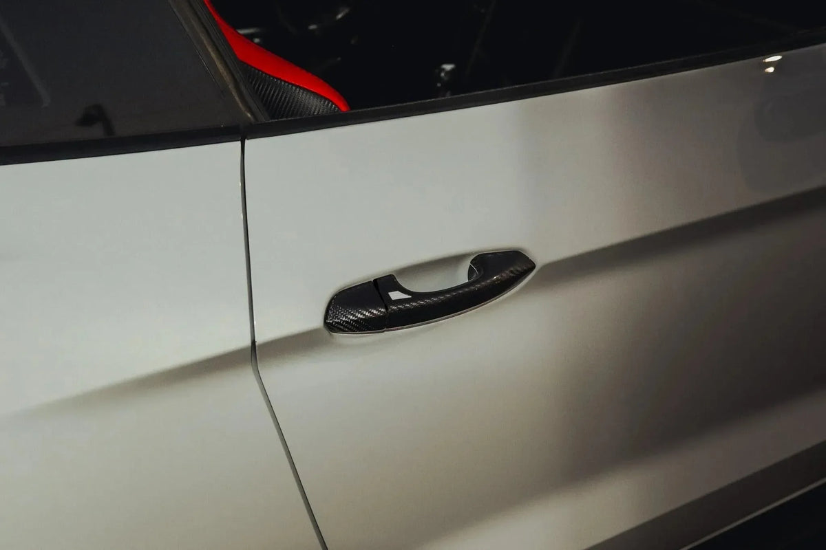 Real carbon fiber door handle cover on white car, sleek exterior auto accessory for performance vehicles