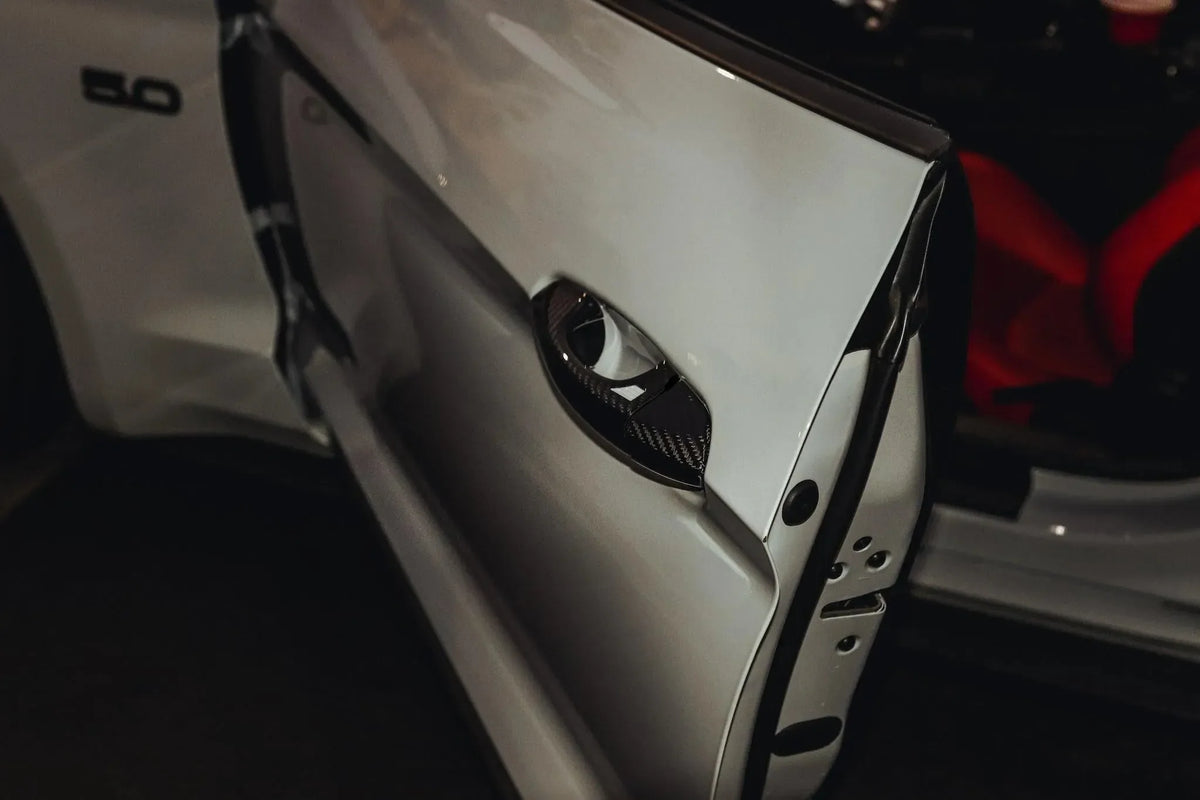 Real carbon fiber door handle cover on white Ford Mustang GT, sleek exterior auto accessory