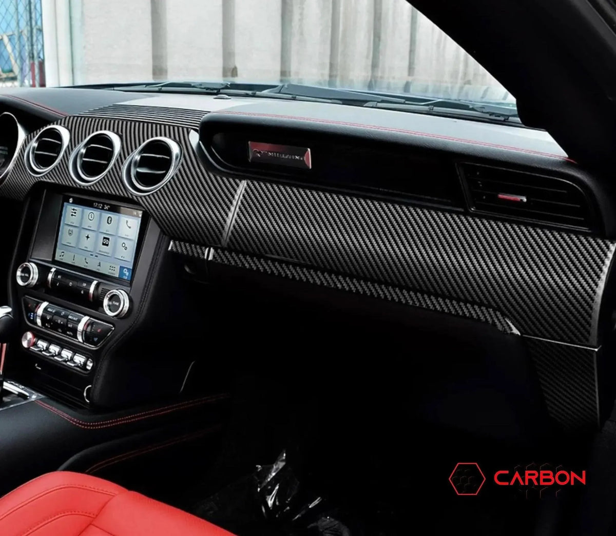 Carbon fiber dashboard trim for Ford Mustang interior with red stitching and touchscreen display