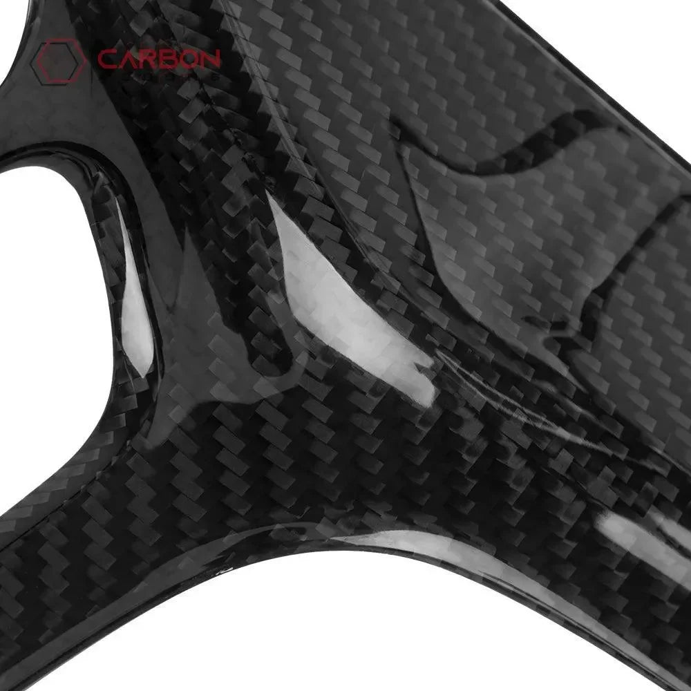 Glossy real carbon fiber automotive part with woven texture and red logo detail
