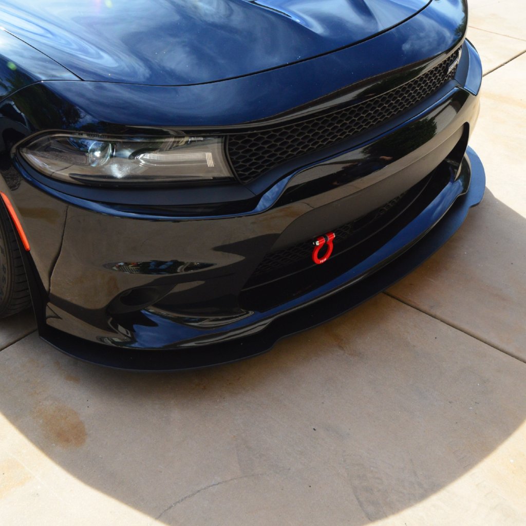 Close-up of a blue car's front grille with a logo on a tiled floor.