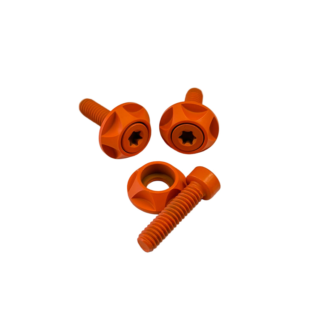 Three orange screws on a white background