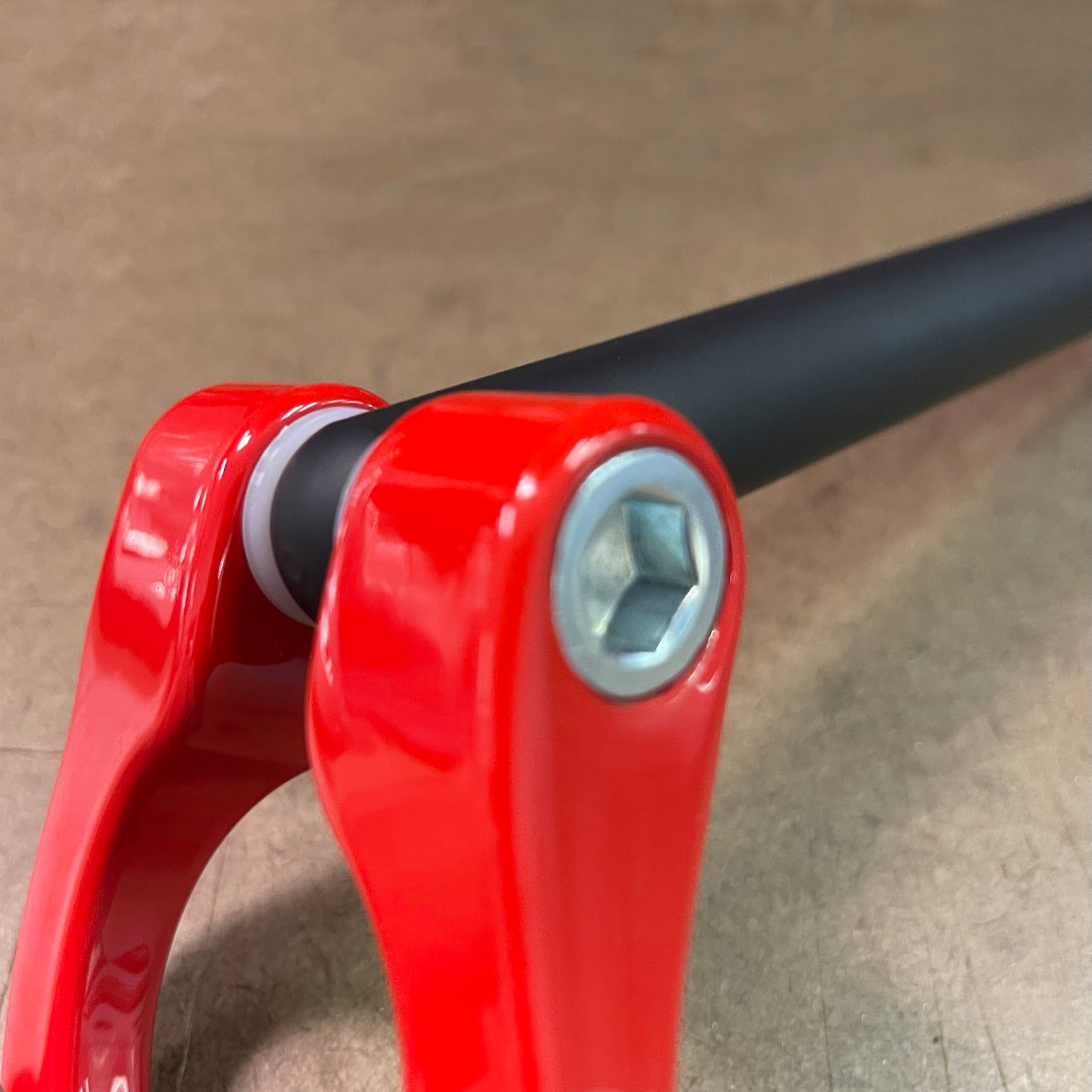 Close-up of red handlebar with black grip on a beige background