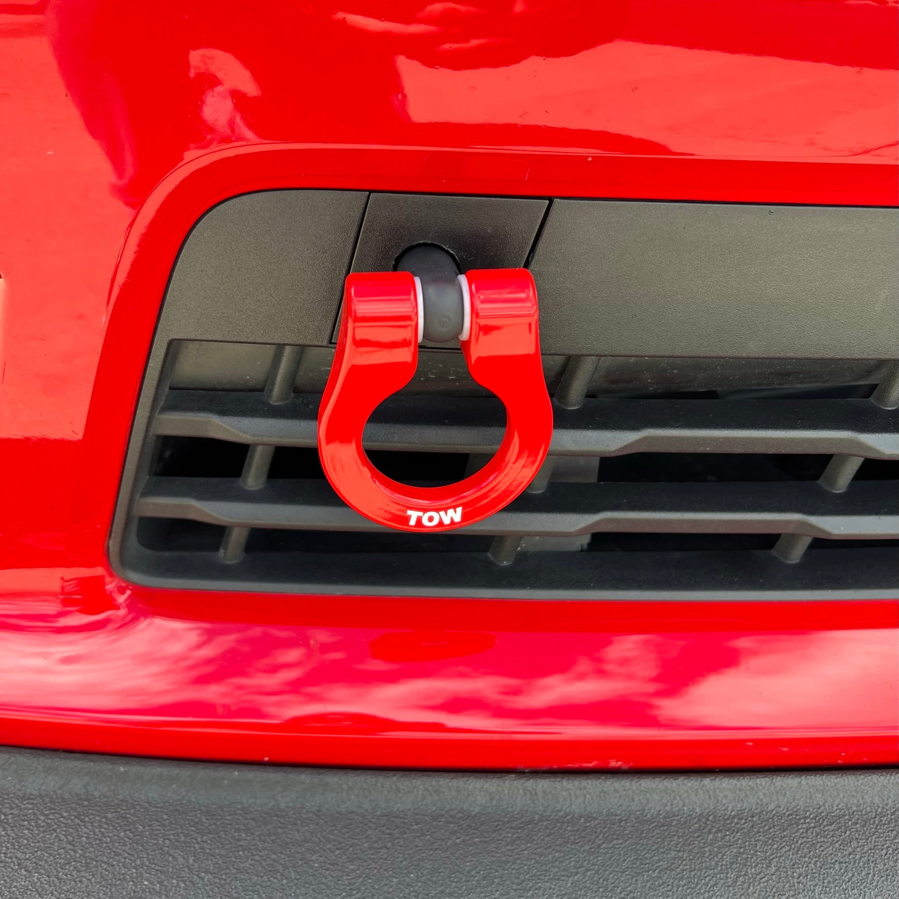 Red tow hook on a red vehicle's grille