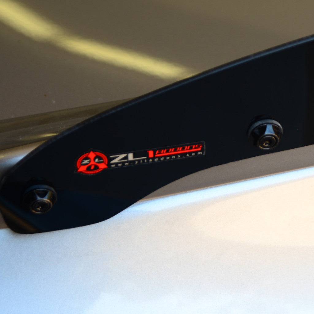 Close-up of a black metal component with a logo on a white surface